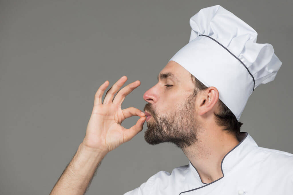 a male chef making a tasty posture to represent the taste of organic food