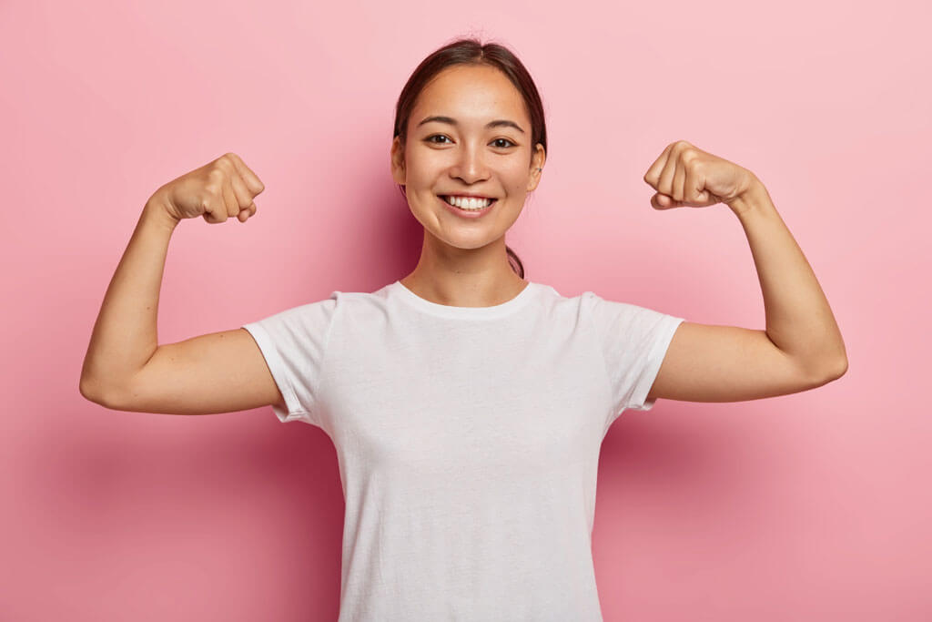 a woman showing biceps to present the health benefits of organic food