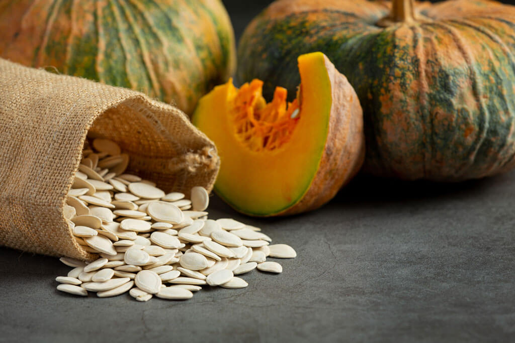 image showing pumpkin seeds and pumpkin in the background