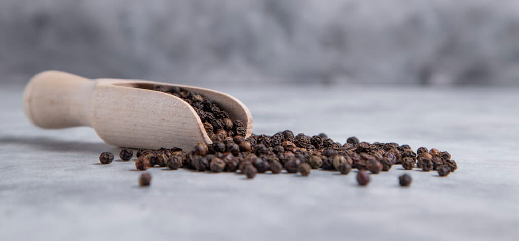 image showing black perpper in a wooden spoon